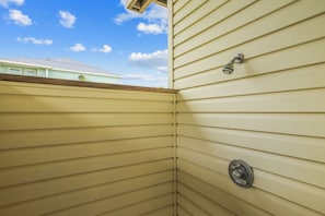 A corner of a building with horizontal siding and a metal door.