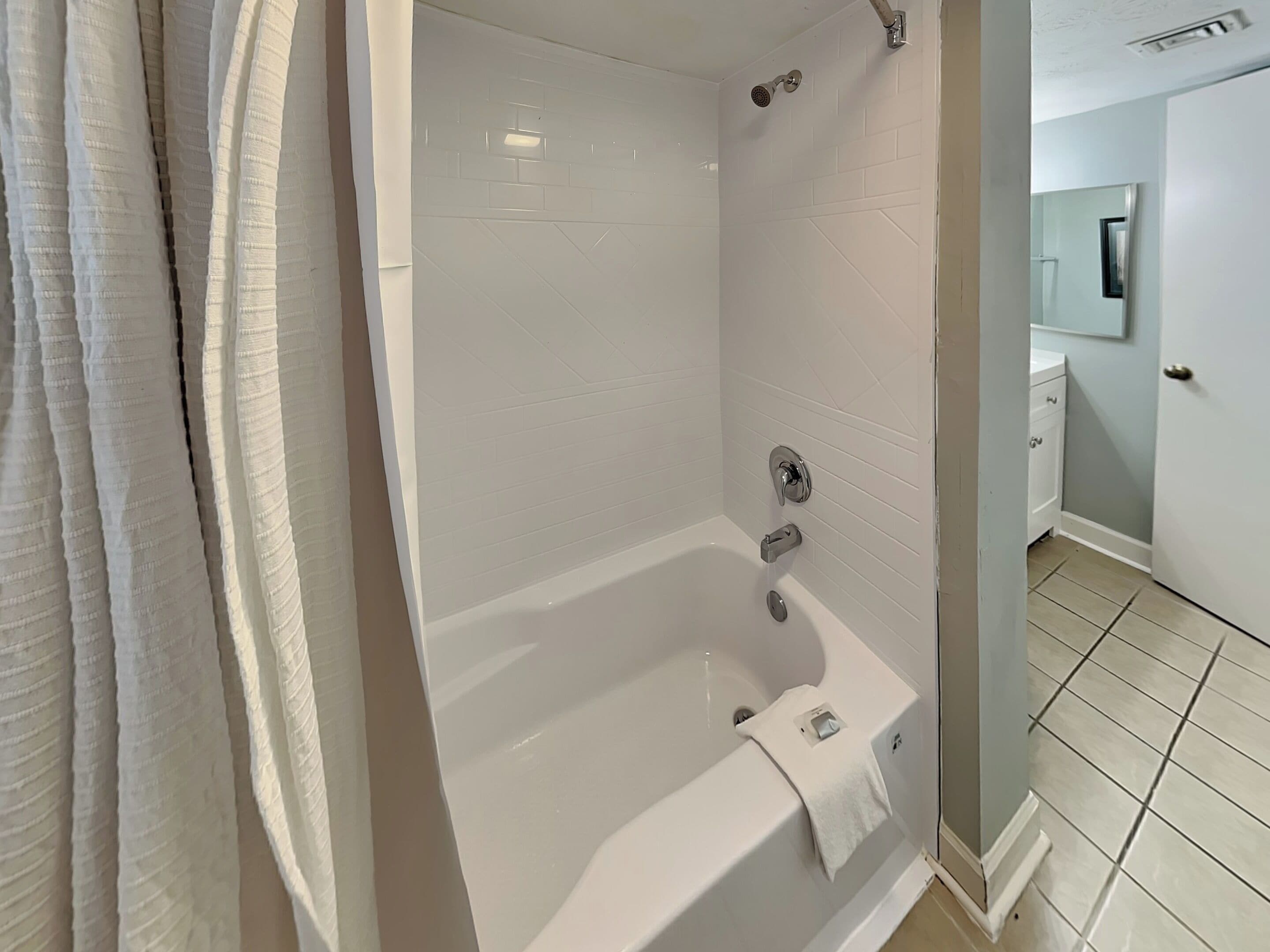A modern bathroom with a freestanding bathtub, a showerhead, and a toilet.