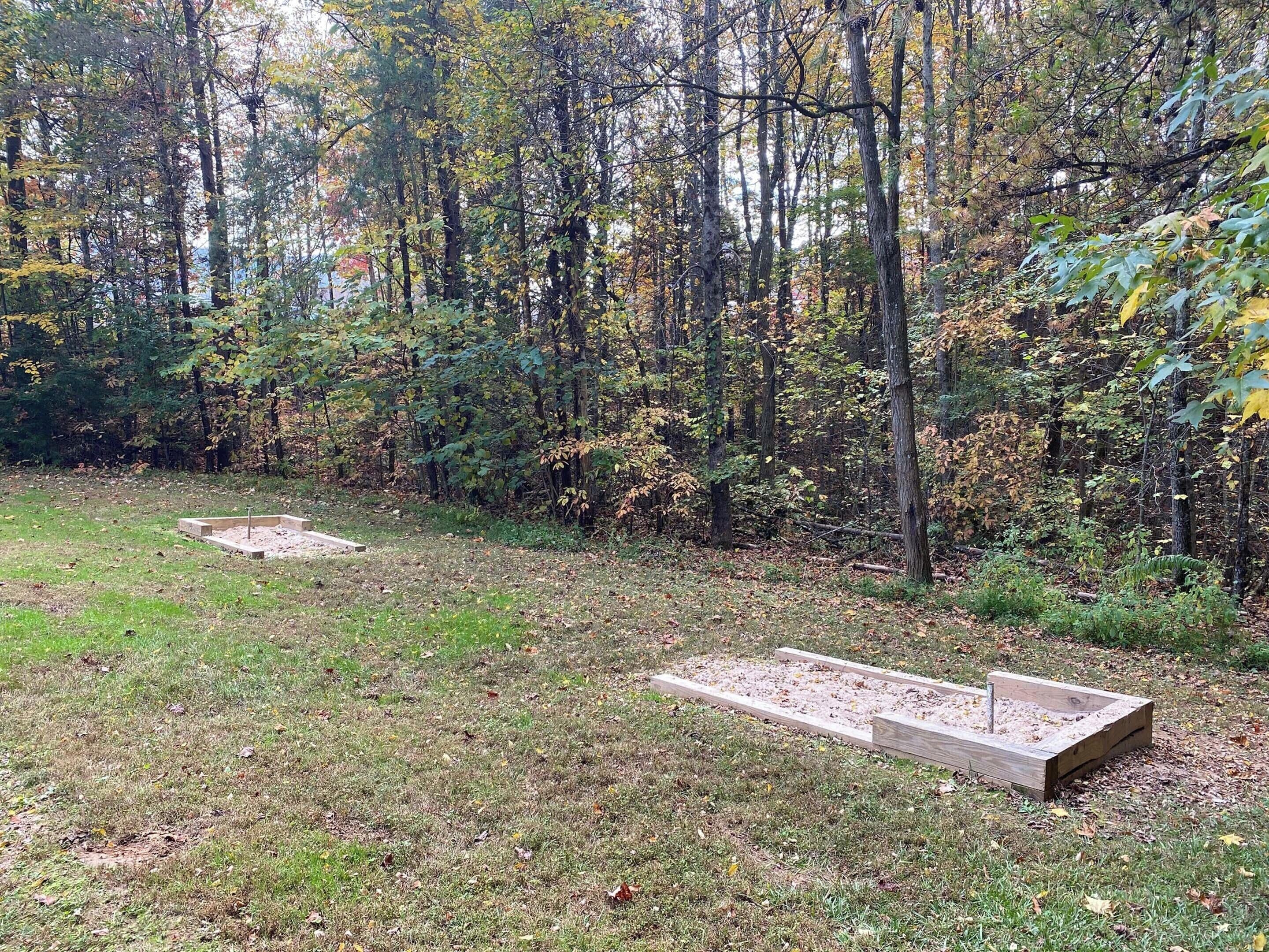 Une zone boisée où se trouvent deux structures rectangulaires en béton.