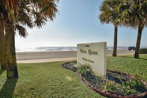 A sign for Ocean Grove with a view of the beach and palm trees. - Pelican View by Ryson Vacation Rentals (Galveston)