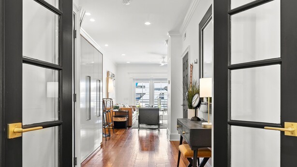 A hallway with wooden flooring, a dining area with a table and chairs, and a desk with a lamp. - Waterfront, Sunset Views! Historic Dwtn-King Bed-Luxury with Free Parking!  (Wilmington)