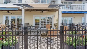 A gated entrance to a private residence with a covered patio area, outdoor furniture, and a sign indicating it is a private residence. - Waterfront, Sunset Views! Historic Dwtn-King Bed-Luxury with Free Parking!  (Wilmington)