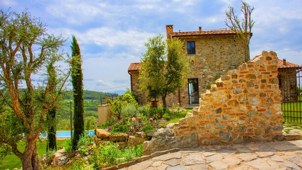 A stone house with a garden, a swimming pool, and a stone wall. - Wonderful Private Villa With Pool in Riparbella (Riparbella)