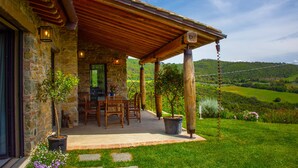 A stone building with a covered patio, outdoor seating, and a view of the countryside. - Wonderful Private Villa With Pool in Riparbella (Riparbella)