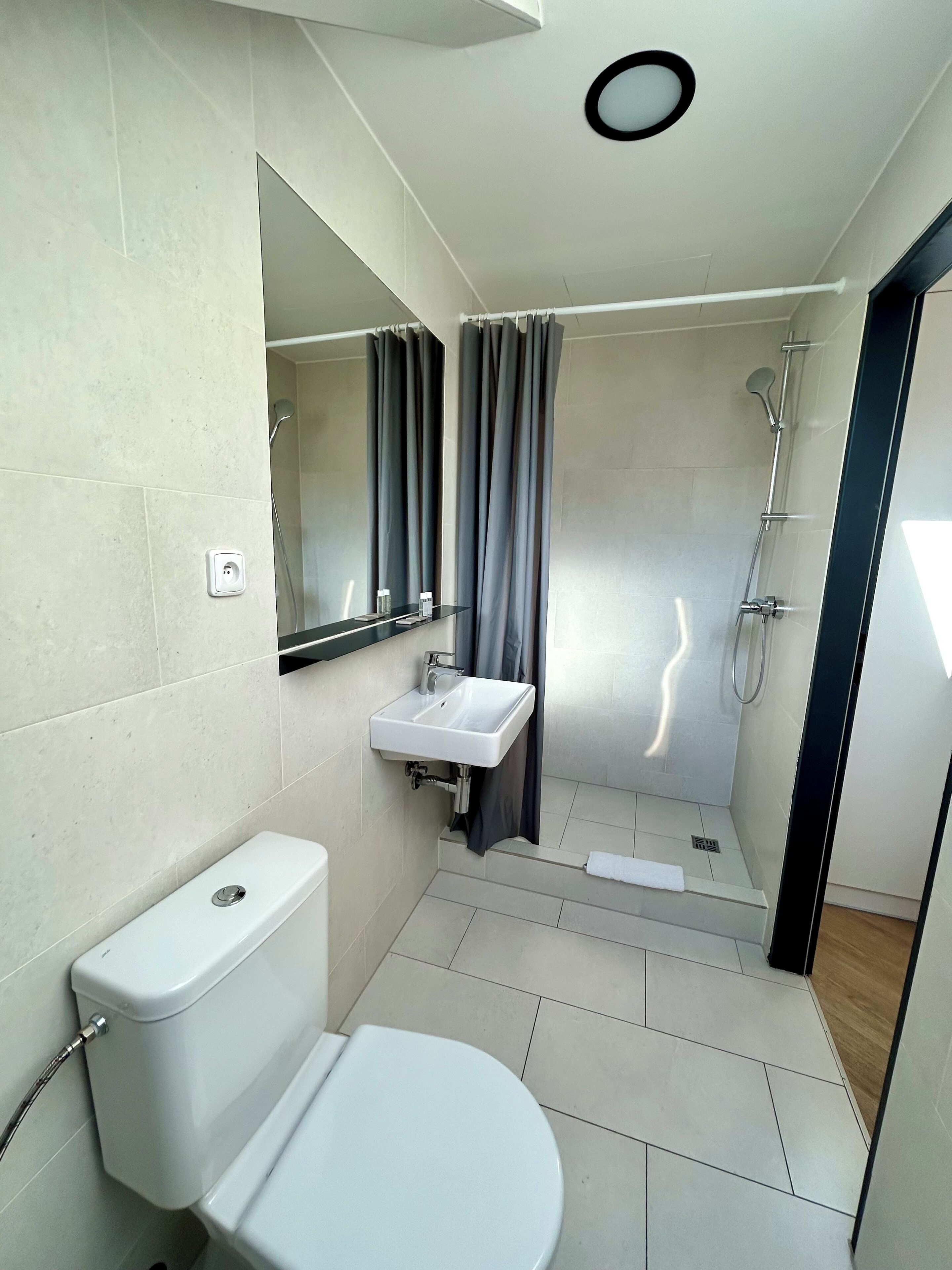 A modern bathroom with a toilet, sink, and shower.