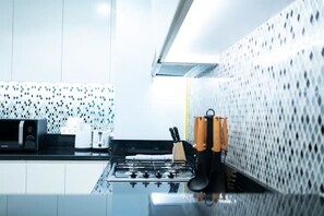 A modern kitchen with a gas stove, a microwave, and a toaster. - Paramount Midtown 2BR with Burj Khalifa view (Dubai)