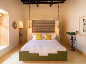 A bedroom with a bed, bedside tables, a hanging light fixture, a wall-mounted clock, and a framed picture. - La Valise San Miguel de Allende, Member of Small Luxury Hotels (San Miguel de Allende)