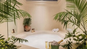 A spa room with a large bathtub, potted plants, and a bottle of champagne. - La Valise San Miguel de Allende, Member of Small Luxury Hotels (San Miguel de Allende)