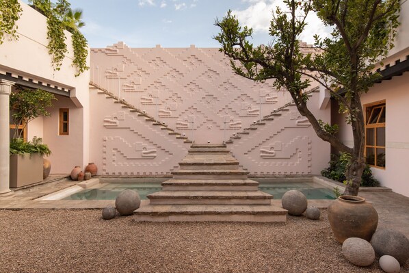 A courtyard with a pool, stone steps, and decorative wall. - La Valise San Miguel de Allende, Member of Small Luxury Hotels (San Miguel de Allende)