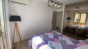 Un dormitorio con una cama grande, una lámpara de pie y un espejo.