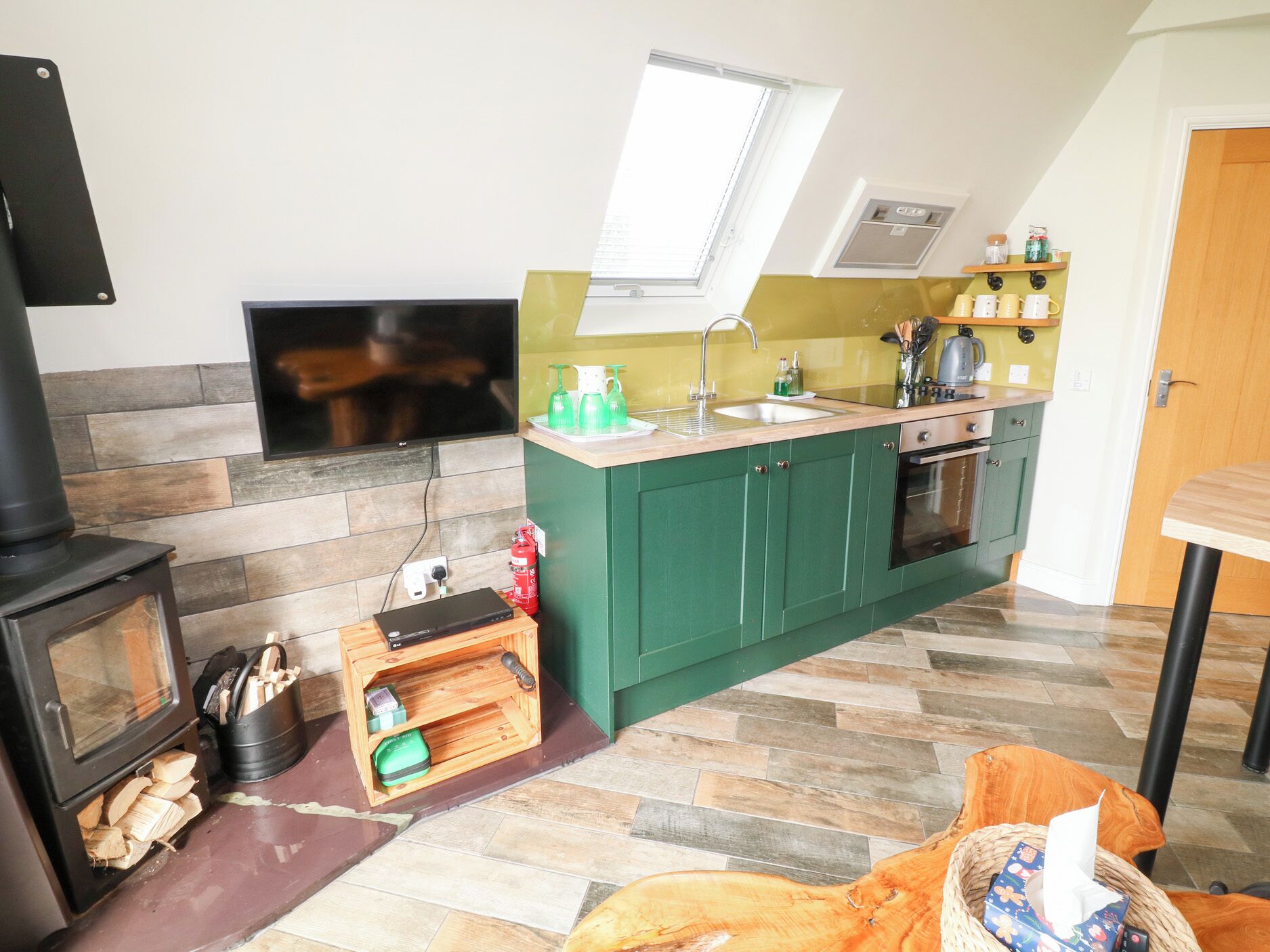 A compact kitchen with a built-in oven, a sink, and a window above the countertop.