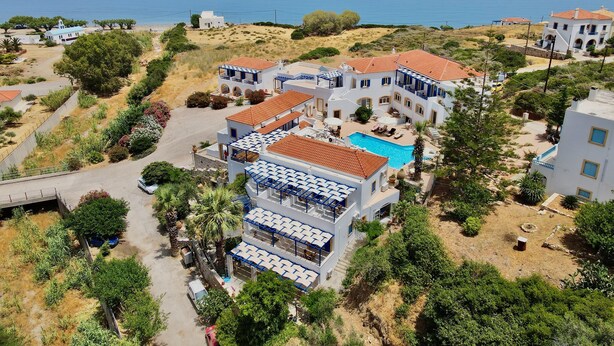 Una località balneare con diversi edifici, una piscina e vista sul mare.