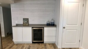 A compact kitchen with white cabinetry, a built-in oven, and a wooden floor.