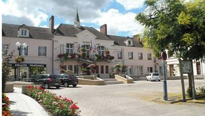 A building with a church steeple, a sign for 'Egalite Fraternite', and a flower-adorned entrance. - Location Vignerons (Neuvy-sur-Loire)