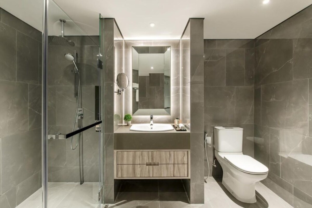 A modern bathroom with a glass shower enclosure, a sink with a mirror, and a toilet.
