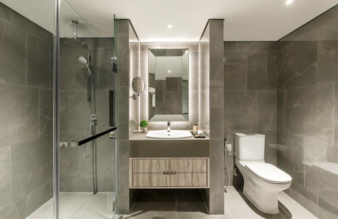 A modern bathroom with a glass shower enclosure, a sink with a mirror, and a toilet.