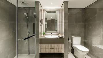 A modern bathroom with a glass shower enclosure, a sink with a mirror, and a toilet.