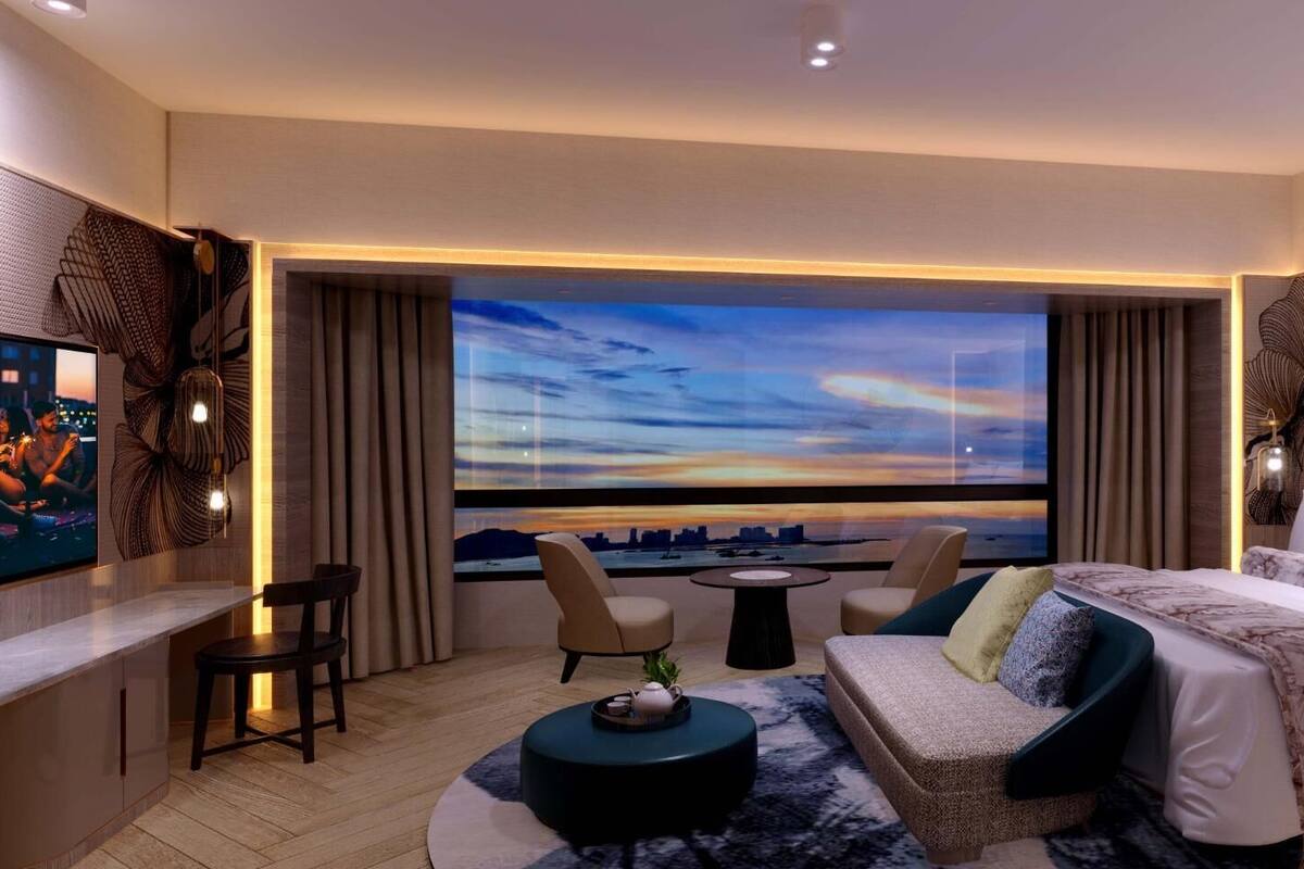 A modern hotel room with a large window, a sofa, a bed, and a small table.
