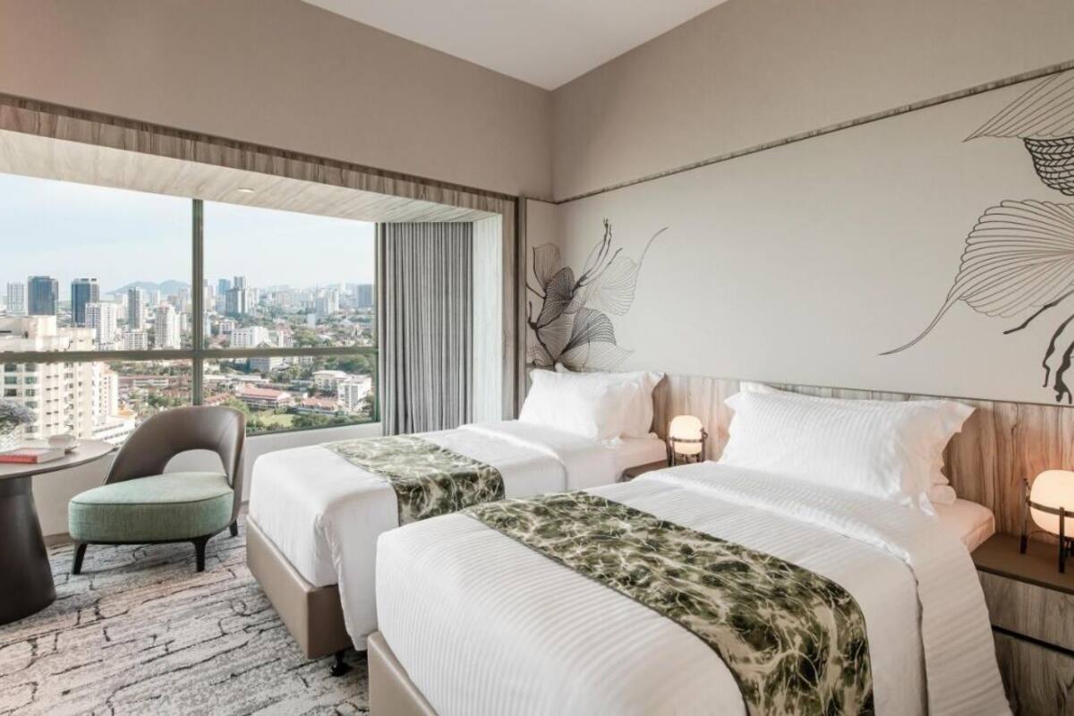A hotel room with two beds, a view of the city, a large abstract painting, and a cityscape visible through the window.