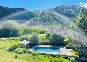 Piscina rodeada de exuberante vegetación y montañas.