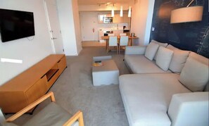 Relax in a spacious living room with a large L-shaped sofa, entertainment unit, and flat-screen TV.