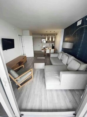 Relax in this spacious living area with a large sofa, flat-screen TV, and dining space.