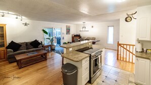 Un espacio habitable amplio con cocina, comedor y escalera.