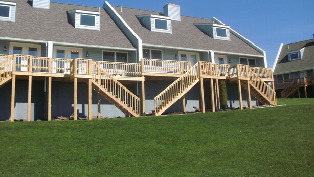Un edificio residencial de varios pisos con balcones de madera y escaleras exteriores.