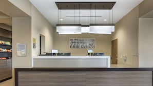 A reception area with a modern desk, two computer monitors, and a hanging light fixture. - Sleep Inn North - Central York (York)