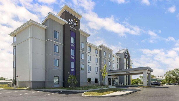 A Sleep Inn by Choice Hotel with a modern design, a parking lot, and a covered entrance. - Sleep Inn North - Central York (York)