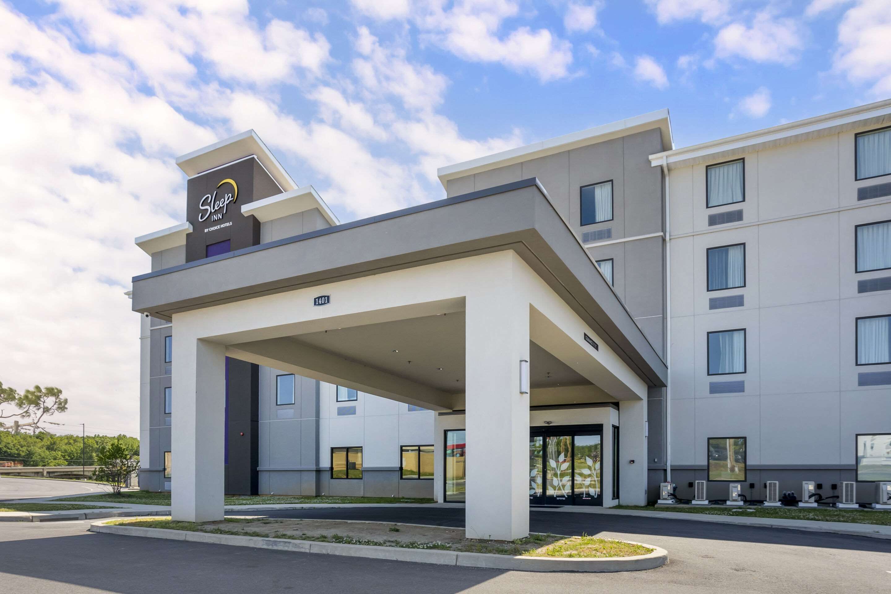 A Sleep Inn hotel with a modern design, featuring a covered entrance and multiple windows.