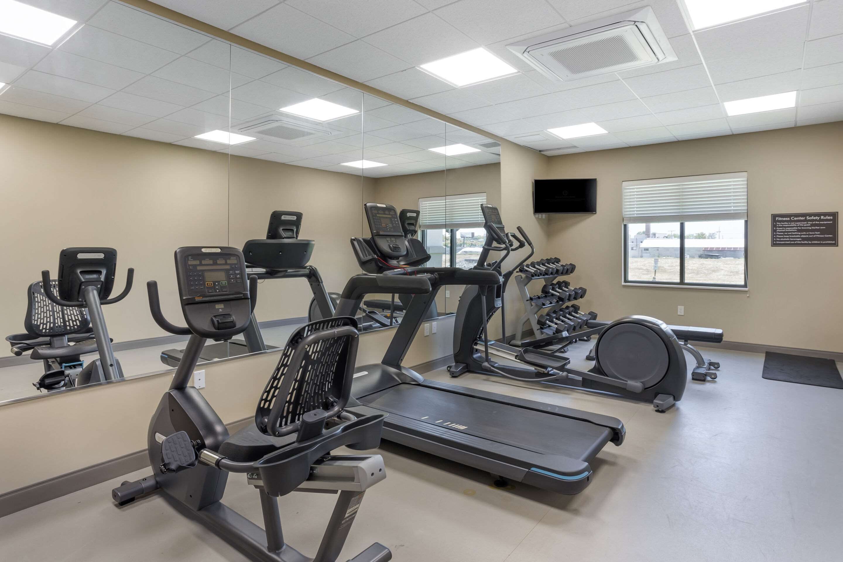 Centre de fitness amb cintes de córrer, el·líptiques i peses lliures.