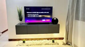 Un téléviseur à écran plat, fixé sur une étagère murale, affiche l’écran d’inscription à Netflix.