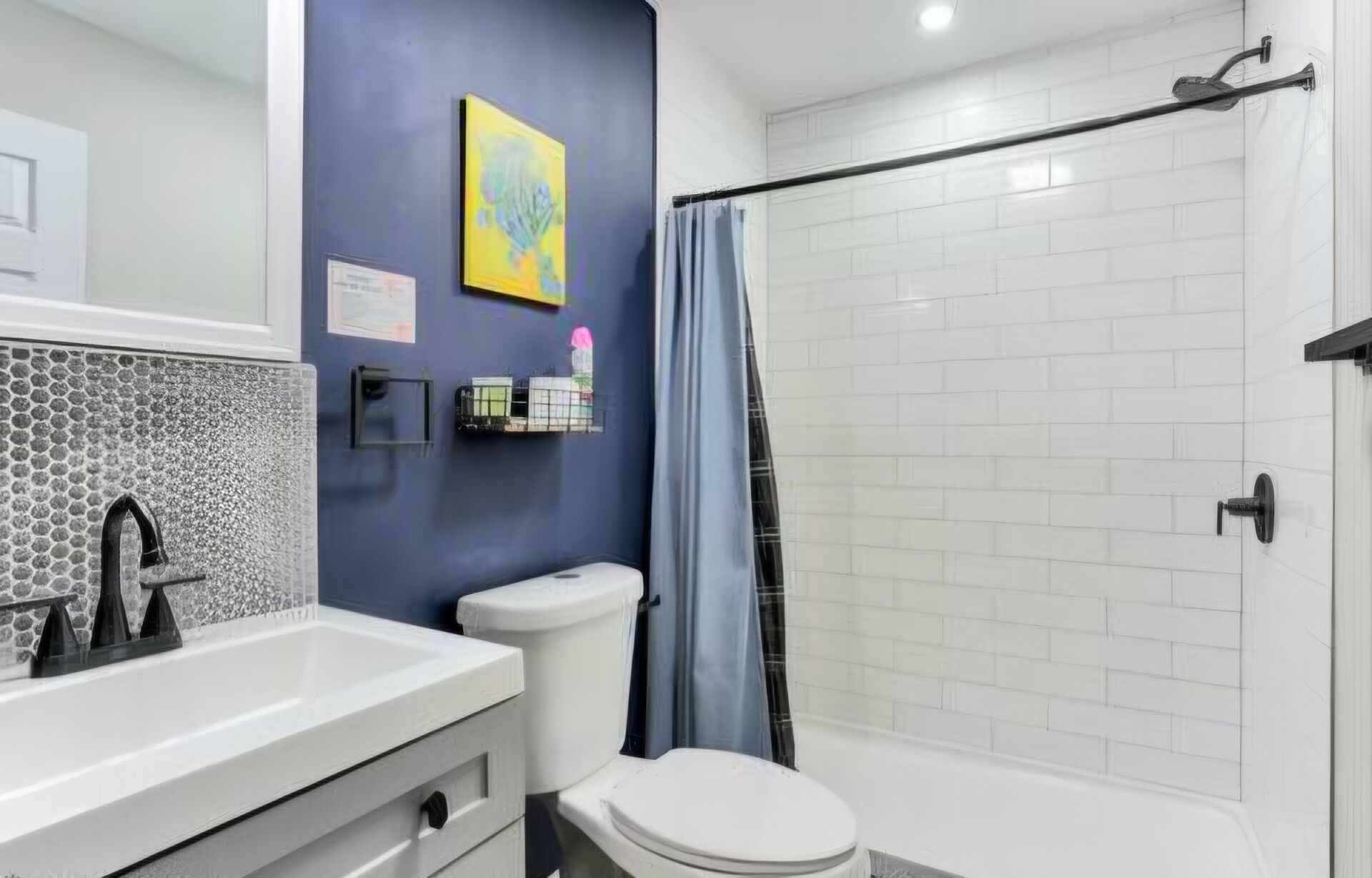 Une salle de bain avec un lavabo blanc, des toilettes et un espace douche.