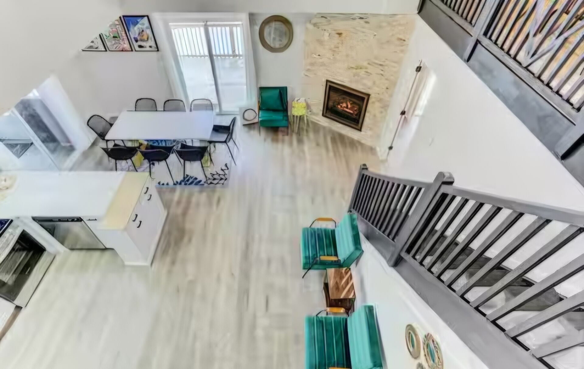 Un comedor con una mesa y sillas blancas, una chimenea y una escalera.