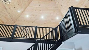 A wooden interior with a staircase and a chandelier.