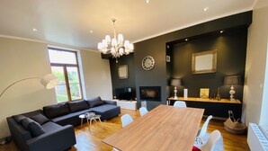 Ein modernes Wohnzimmer mit einem dunkelgrauen Sofa, einem Holzesstisch und einem Kamin.