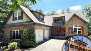 Ein zweistöckiges Haus mit einer Stein-Fassade, einer großen Garage und einer überdachten Veranda.