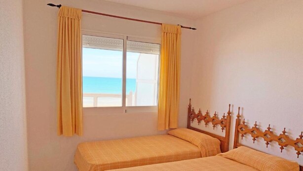 A room with two beds, a window with curtains, and a view of the sea. - Las Vegas 3000 (Peniscola)