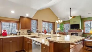 A kitchen with wooden cabinets, a large island, and a built-in oven. - 3 Bedroom Townhome in Downtown Breckenridge, off Main Street With Pool, and Hot Tubs (Breckenridge)