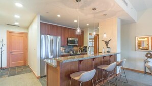 A modern kitchen with a central island, stainless steel appliances, and pendant lighting. - Luxury Ski in, Ski out 3 Bedroom Mountain Resort Vacation Rental in the Heart of Snowmass Base Village (Snowmass Village)