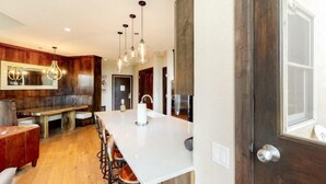 A modern kitchen with a central island, wooden cabinetry, and pendant lighting. - Premier Ski in, Ski-out 2 Bedroom Condo With Spectacular Views, Heated Outdoor Pool and Hot Tub, Short Walk to Village (Snowmass Village)