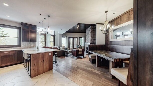 A modern kitchen with a central island, dark wood cabinetry, and a stone accent wall.