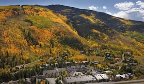 A town nestled in a valley with autumn foliage, surrounded by hills.