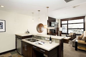 A modern kitchen with a large island, built-in appliances, and a dining area with a view.