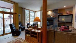 A cozy living room with a fireplace, a television, and comfortable seating. - 2 Bedroom Platinum Condo Near Chairlift in Cascade Village With Pool and Hot Tub (Vail)