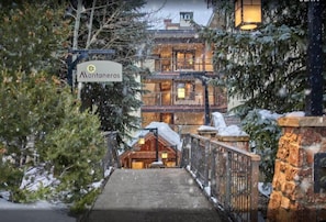 Step into the grand entrance of Montaneros, where a majestic staircase leads to a gated area amidst snow-covered surroundings.