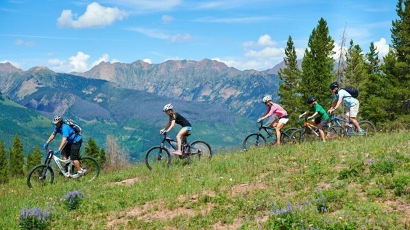 A group of cyclists on a mountain trail with a scenic mountain backdrop. - Comfortable and Cozy 2 Bedroom Condo Near Chair Lift 20 in Cascade Village - Shuttle to Vail Village (Vail)