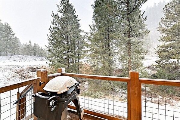 A balcony with a wooden railing overlooking a snowy landscape with tall pine trees. - Family-friendly 3 Bedroom Vacation Rental in West Keystone Resort Along the Snake River With Pool and Hot Tub (Keystone)