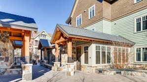 A building with a stone facade, wooden beams, and a covered walkway. - Luxury 2 Bedroom Mountain Vacation Residence With Hot Tub, Pool, and Easy Access to Ski Slopes (Breckenridge)